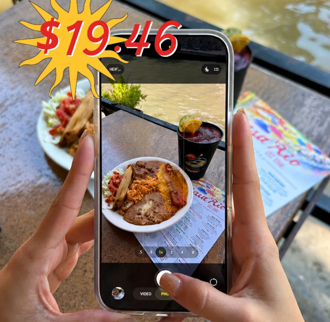 A guest photographing a Casa Rio plate beside the river
