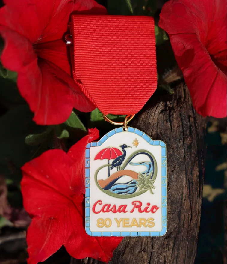 The Casa Rio 80 Years commemorative medal on red flowers